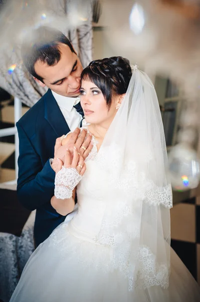Γοητευτική νύφη με γαμπρός αγκαλιάζει και φιλιά στην γιορτή τους γάμο στο πολυτελές εστιατόριο. μπουκέτο λουλούδια, νυφικό φόρεμα. το μοντέρνο ξενοδοχείο αίθουσα νιόπαντρο ζευγάρι atluxury — Φωτογραφία Αρχείου