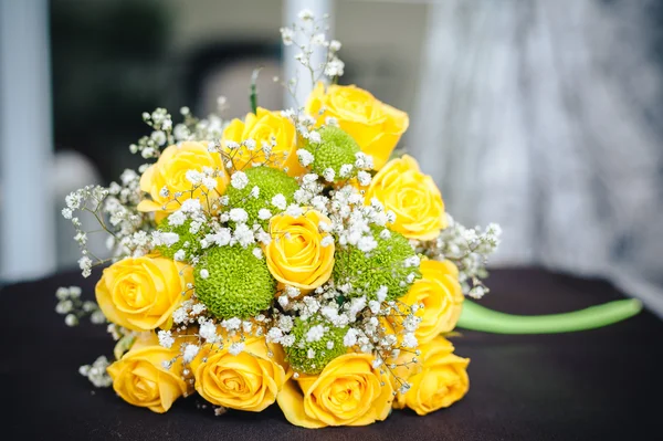 Fresh yellow roses with a checkered ribbon on wooden table — Stock Photo, Image