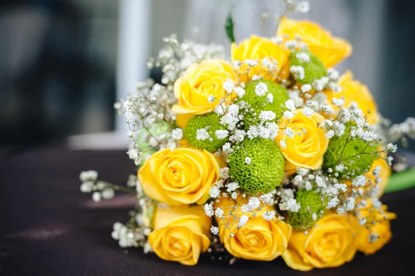 Fresh yellow roses with a checkered ribbon on wooden table — Stock Photo, Image