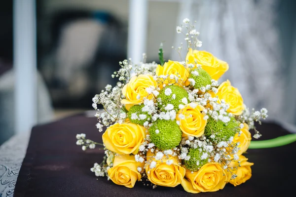 Fresh yellow roses with a checkered ribbon on wooden table — Stock Photo, Image