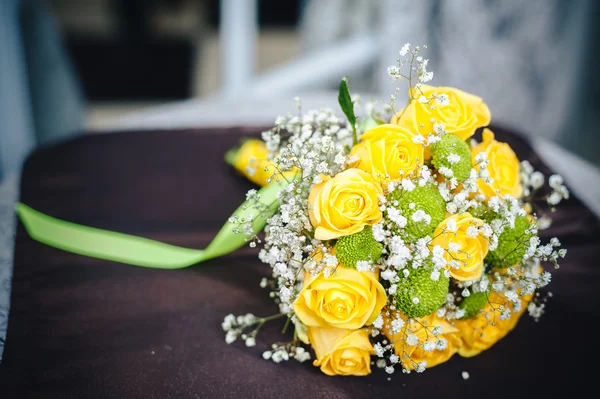 Świeże żółte róże z burzliwą wstążki na drewnianym stole — Zdjęcie stockowe