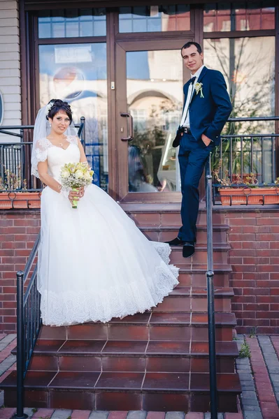 Novia y novio de pie en las escaleras — Foto de Stock