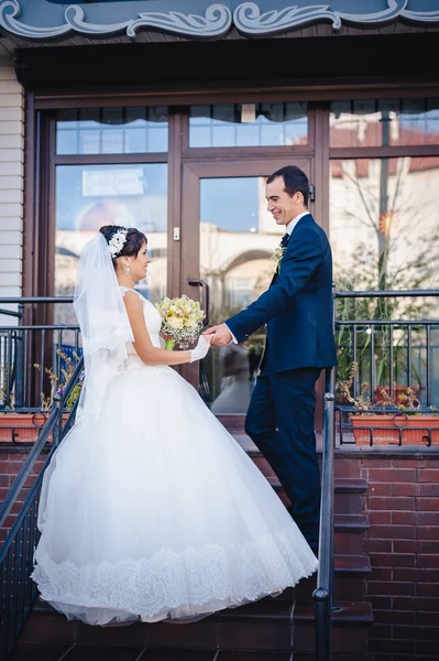 Noiva e noivo em pé nas escadas — Fotografia de Stock