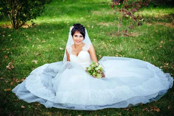 Portret van mooie jonge bruid heldere boeket in handen houden. huwelijksfeest. natuur groene achtergrond. vrouw alleen buiten in het park — Stockfoto