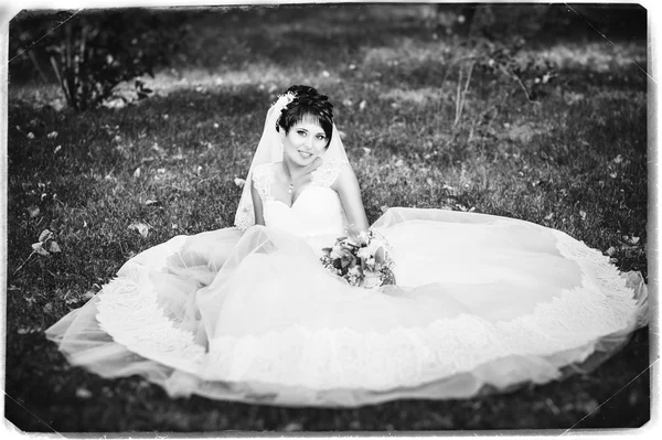 Retrato de hermosa novia joven sosteniendo ramo brillante en las manos. celebración de la boda. naturaleza fondo verde. mujer sola al aire libre en el parque — Foto de Stock