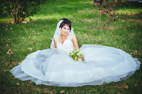 Retrato de bela noiva jovem segurando buquê brilhante em mãos. Celebração de casamento. natureza fundo verde. mulher sozinha ao ar livre no parque — Fotografia de Stock