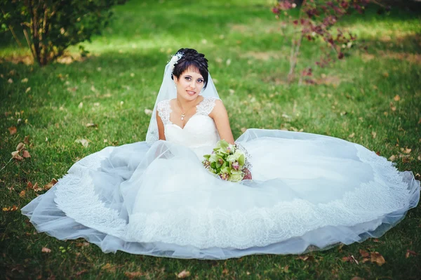 Retrato de bela noiva jovem segurando buquê brilhante em mãos. Celebração de casamento. natureza fundo verde. mulher sozinha ao ar livre no parque — Fotografia de Stock