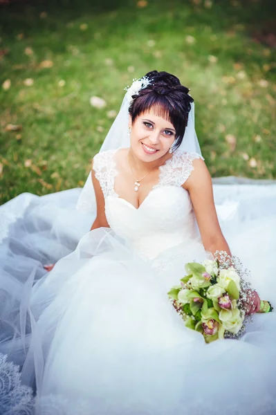 Retrato de hermosa novia joven sosteniendo ramo brillante en las manos. celebración de la boda. naturaleza fondo verde. mujer sola al aire libre en el parque —  Fotos de Stock