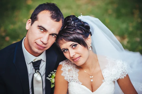 Молодая пара целуется в свадебном платье. Невеста с букетом цветов — стоковое фото