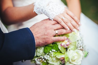 Gelin ve damat gelin buketi tutarak yakından