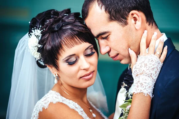 Молодая пара целуется в свадебном платье. Невеста с букетом цветов — стоковое фото