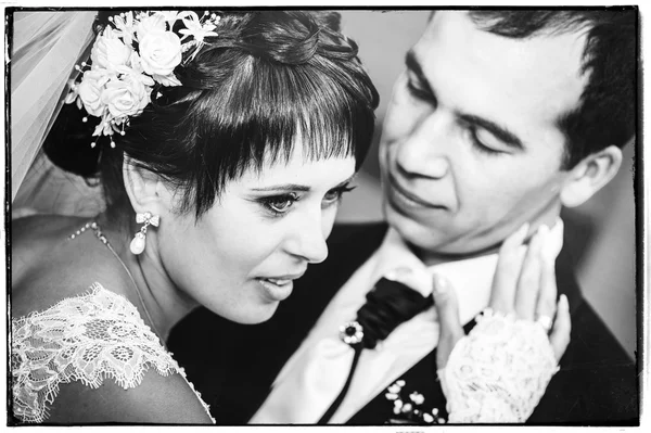 Jeune couple embrassant en robe de mariée. Mariée tenant bouquet de fleurs — Photo