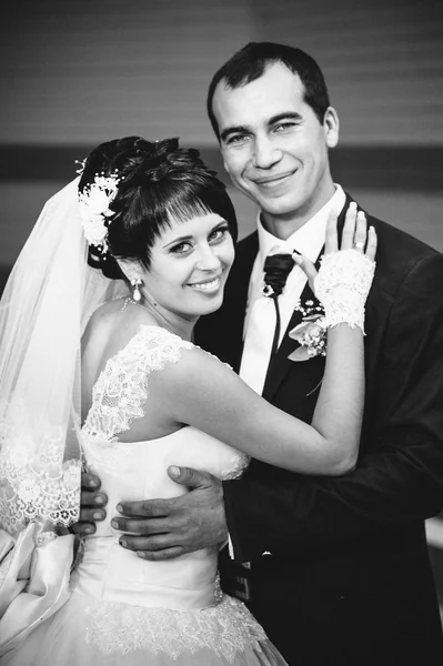 Jeune couple embrassant en robe de mariée. Mariée tenant bouquet de fleurs — Photo