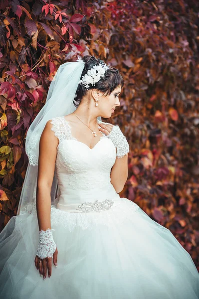 Potret pengantin muda yang cantik memegang buket cerah di tangan. Perayaan pernikahan. latar belakang hijau alam. Wanita sendirian di luar rumah di taman — Stok Foto