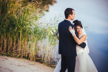 Düğün: gelin ve damat sahil üzerinde.