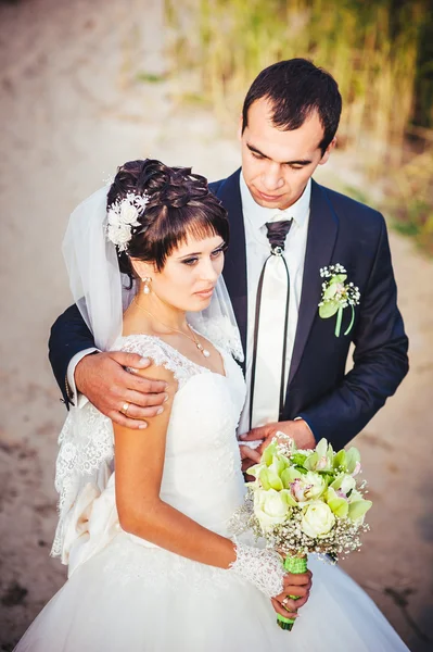 Boda: novia y novio en la orilla del mar . — Foto de Stock