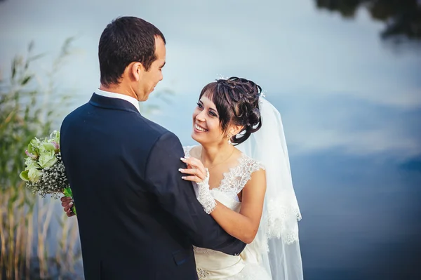 Boda: novia y novio en la orilla del mar . — Foto de Stock