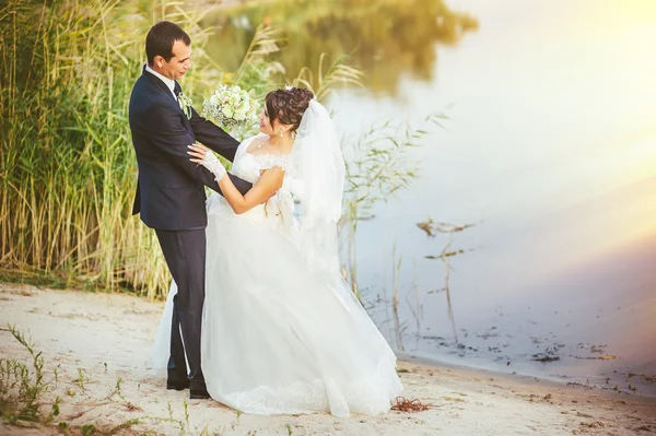 Esküvő: menyasszony és a vőlegény a tengerparton. — Stock Fotó