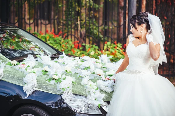 La mariée près d'une voiture de mariage noire — Photo