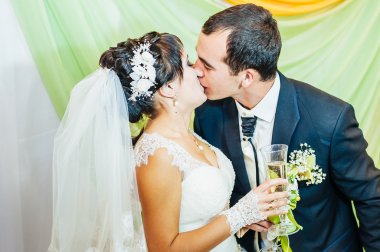 Büyüleyici gelinle damat kucaklayan, onların düğün kutlama lüks restoranda öper. buket çiçek, gelinliğin. Yeni evli çift atluxury modern otel binası