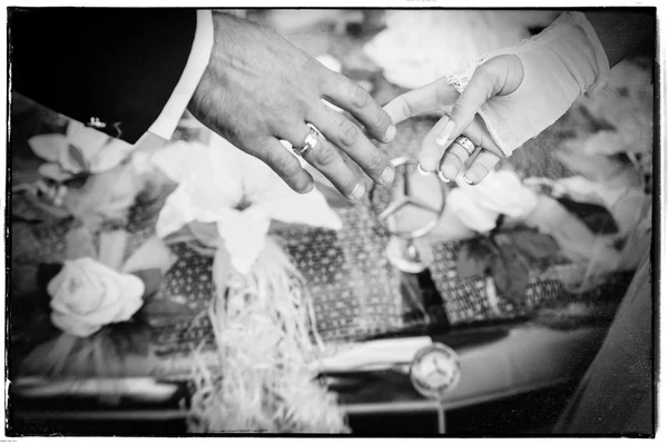 Mãos da noiva e do noivo. buquê de casamento no carro preto — Fotografia de Stock