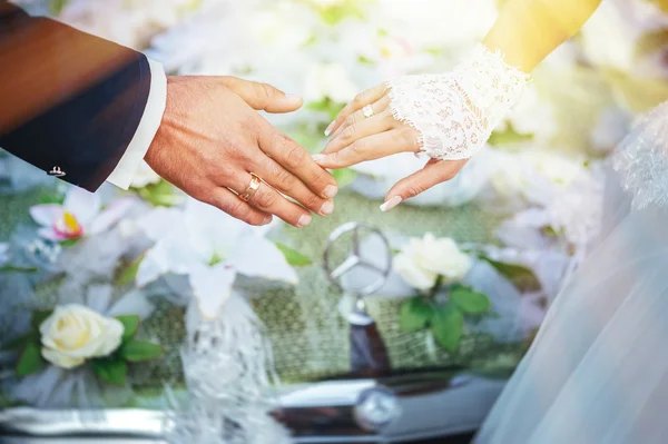 A menyasszony és a vőlegény kezét. menyasszonyi csokor a fekete autó — Stock Fotó