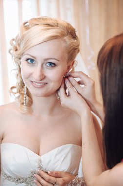 Gelin hazırlanıyor. güzel gelin beyaz düğün elbise parlak makyaj ve saç modeli ile. Damat için bekleyen mutlu seksi kız. Gelin elbiseli romantik Bayan var düğün için son hazırlık ve sunuş.
