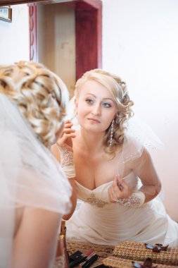 Gelin hazırlanıyor. güzel gelin beyaz düğün elbise parlak makyaj ve saç modeli ile. Damat için bekleyen mutlu seksi kız. Gelin elbiseli romantik Bayan var düğün için son hazırlık ve sunuş.