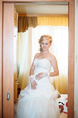 Gelin hazırlanıyor. güzel gelin beyaz düğün elbise parlak makyaj ve saç modeli ile. Damat için bekleyen mutlu seksi kız. Gelin elbiseli romantik Bayan var düğün için son hazırlık ve sunuş.