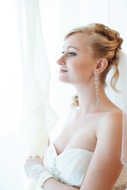 Gelin hazırlanıyor. güzel gelin beyaz düğün elbise parlak makyaj ve saç modeli ile. Damat için bekleyen mutlu seksi kız. Gelin elbiseli romantik Bayan var düğün için son hazırlık ve sunuş.