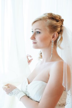 Gelin hazırlanıyor. güzel gelin beyaz düğün elbise parlak makyaj ve saç modeli ile. Damat için bekleyen mutlu seksi kız. Gelin elbiseli romantik Bayan var düğün için son hazırlık ve sunuş.