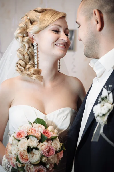 Χαρούμενος νεαρός νύφη και ο γαμπρός την ημέρα του γάμου τους. Γαμήλιο ζεύγος - νέα οικογένεια. γαμήλιο φόρεμα. Γαμήλια νυφικό μπουκέτο λουλούδια — Φωτογραφία Αρχείου
