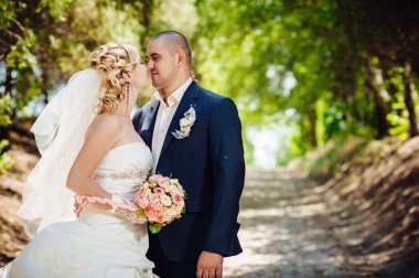 Gelin ve damat, düğün günü açık havada yürüyüş Doğa bahar. mutlu yeni evli kadın ve erkek yeşil park kucaklayan gelin çift. sevgi dolu evlilik çift açık.