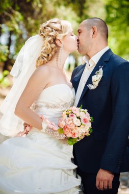 Gelin ve damat, düğün günü açık havada yürüyüş Doğa bahar. mutlu yeni evli kadın ve erkek yeşil park kucaklayan gelin çift. sevgi dolu evlilik çift açık.