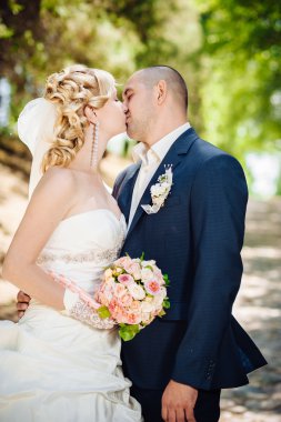 Gelin ve damat, düğün günü açık havada yürüyüş Doğa bahar. mutlu yeni evli kadın ve erkek yeşil park kucaklayan gelin çift. sevgi dolu evlilik çift açık.