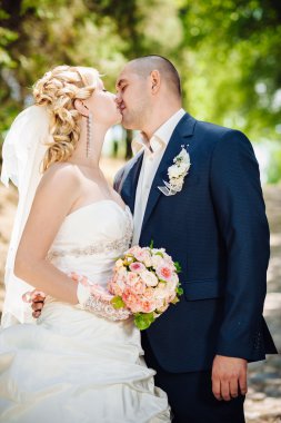 Gelin ve damat, düğün günü açık havada yürüyüş Doğa bahar. mutlu yeni evli kadın ve erkek yeşil park kucaklayan gelin çift. sevgi dolu evlilik çift açık.