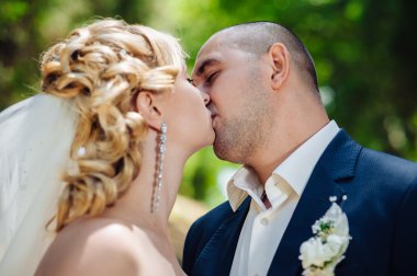 Gelin ve damat, düğün günü açık havada yürüyüş Doğa bahar. mutlu yeni evli kadın ve erkek yeşil park kucaklayan gelin çift. sevgi dolu evlilik çift açık.