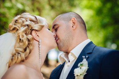 Gelin ve damat, düğün günü açık havada yürüyüş Doğa bahar. mutlu yeni evli kadın ve erkek yeşil park kucaklayan gelin çift. sevgi dolu evlilik çift açık.