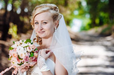 Güzel gelin açık havada. Gelin düğün buket dışında tutarak. Gelin. Saç modeli düğün. Bir bardak güzel bir beyaz gelin açık