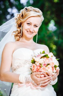 Güzel gelin açık havada. Gelin düğün buket dışında tutarak. Gelin. Saç modeli düğün. Bir bardak güzel bir beyaz gelin açık