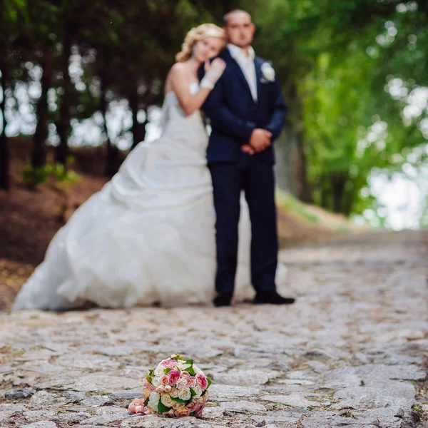 Noiva e noivo no dia do casamento andando ao ar livre na natureza de primavera. Casal nupcial, mulher recém-casada feliz e homem abraçando no parque verde. Casal de amor ao ar livre . — Fotografia de Stock