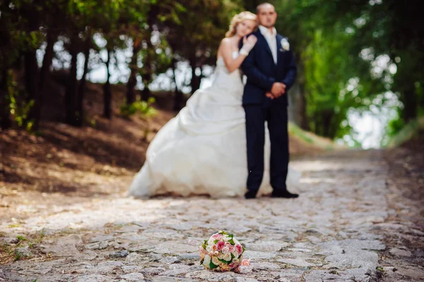 Novia y novio en el día de la boda caminando al aire libre en la naturaleza de primavera. Pareja nupcial, feliz mujer recién casada y hombre abrazándose en el parque verde. Amar pareja de boda al aire libre . —  Fotos de Stock