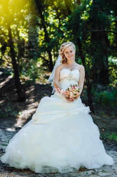 屋外の美しい花嫁。外の結婚式のブーケを持って花嫁。花嫁。結婚式の髪型。美しい白人花嫁の屋外のショット — ストック写真