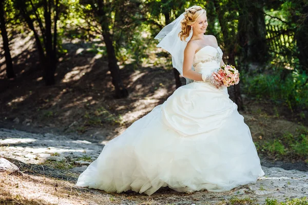 Beautiful bride outdoors. Bride holding wedding bouquet outside. Bride. Wedding hairstyle. A shot of a beautiful caucasian bride outdoor — Stock Photo, Image