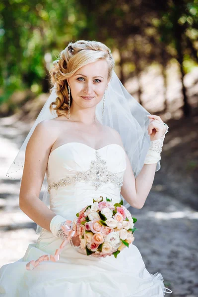 屋外の美しい花嫁。外の結婚式のブーケを持って花嫁。花嫁。結婚式の髪型。美しい白人花嫁の屋外のショット — ストック写真