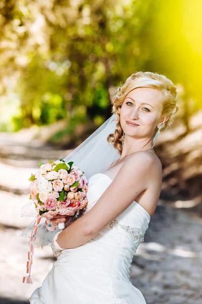 Krásná nevěsta venku. Nevěsta drží svatební kytice venku. Nevěsta. Svatební účes. Panák kavkazské krásná nevěsta venkovní — Stock fotografie