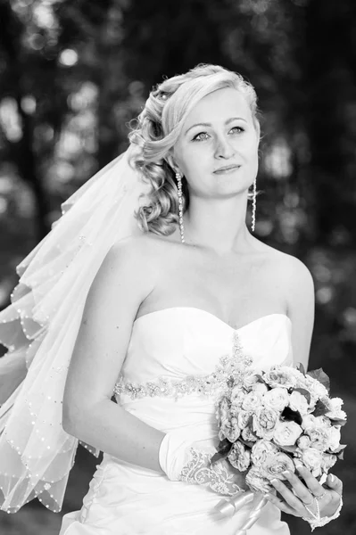 Hermosa novia al aire libre. Novia celebrando el ramo de bodas afuera. Novia. Peinado de boda. Un disparo de una hermosa novia caucásica al aire libre —  Fotos de Stock