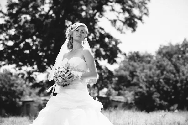 Hermosa novia al aire libre. Novia celebrando el ramo de bodas afuera. Novia. Peinado de boda. Un disparo de una hermosa novia caucásica al aire libre — Foto de Stock