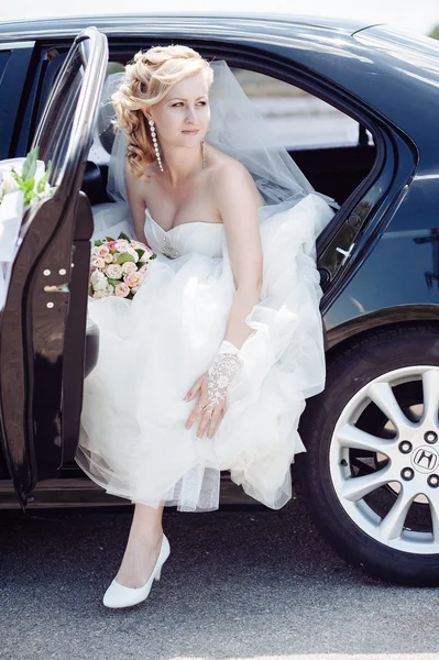 Ritratto di una bella sposa in macchina. ritratto ravvicinato di una sposa piuttosto timida in un finestrino d'auto . — Foto Stock