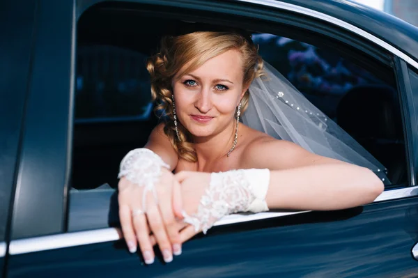 Porträtt av en vacker brud i en bil. närbild porträtt av en ganska blyg brud i en bilfönster. — Stockfoto